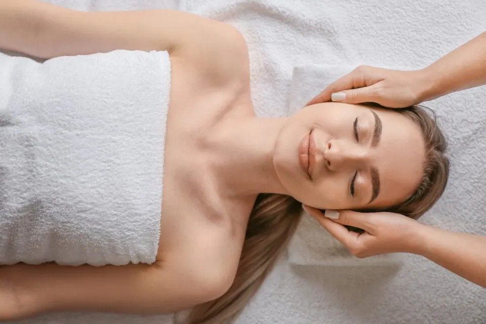 Esthetician performing a facial treatment on a relaxed client