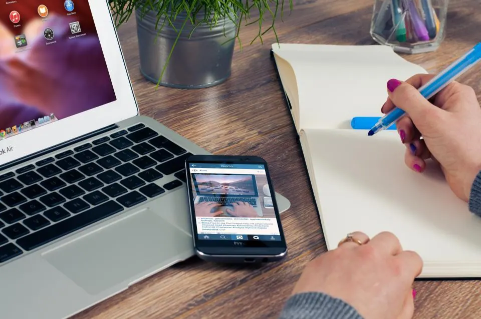 Laptop, phone and notebook on a work desk