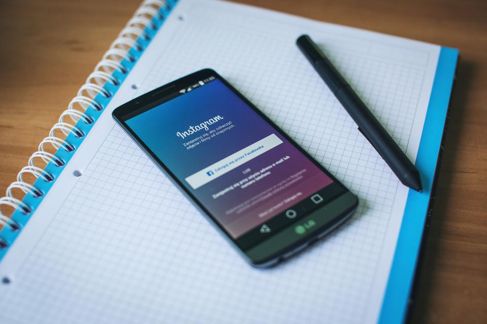 Phone showing Instagram on a notebook